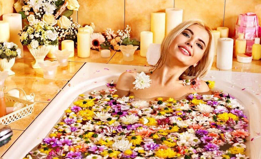 La ragazza prende un bagno con i petali